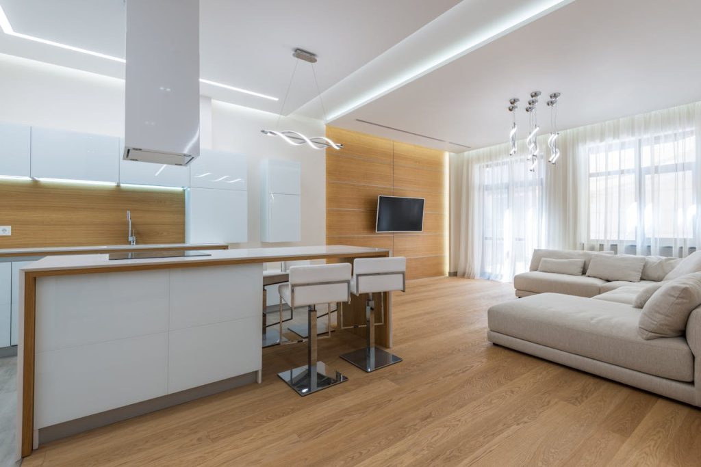 Stylish modern open-plan living area with kitchen, featuring a minimalist design and elegant furnishings.